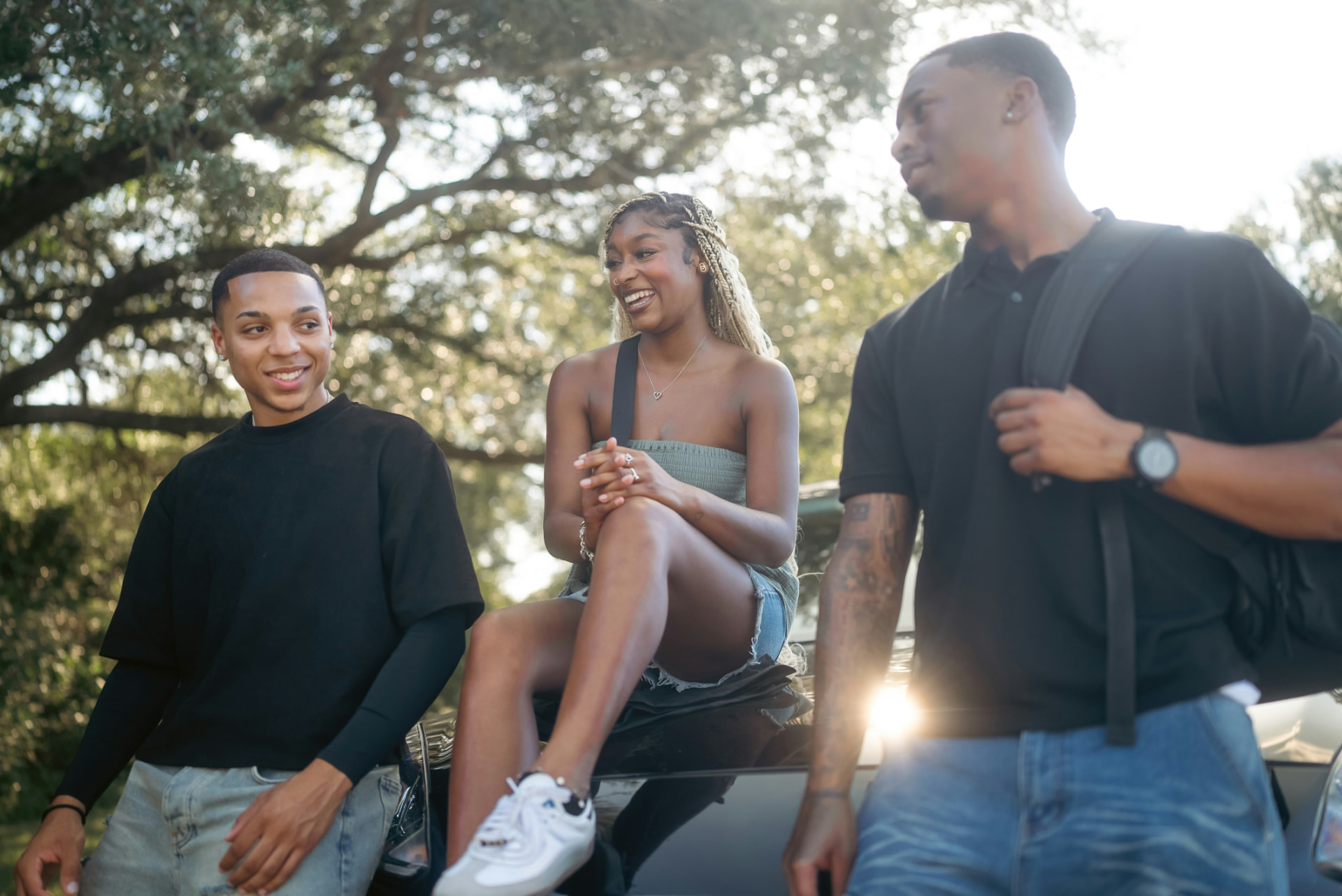 A group of young people talking together outdoors on a sunny day